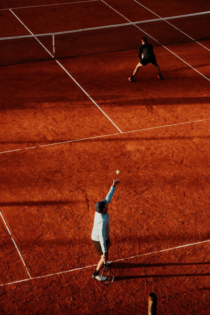 services-03 Dynamic tennis match on red clay court in Buenos Aires, Argentina, captured from above.